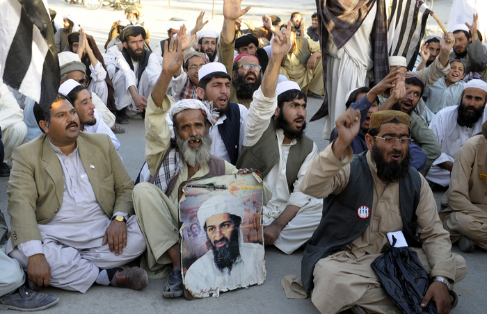 Militanţii Al-Qaeda ţin un poster cu liderul Osama bin Laden, cu ocazia celei de-a doua aniversări a morţi acestuia, la 2 mai 2013. (BANARAS KHAN / AFP / Getty Images)