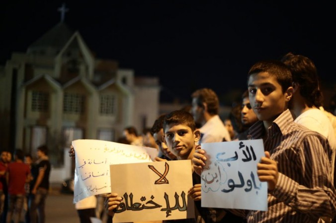 
Protestatarii sirieni se adună pentru a cere eliberarea preotului italian iezuit Paolo Dall'Oglio în nordul oraşului Raqqa la 2 august 2013
