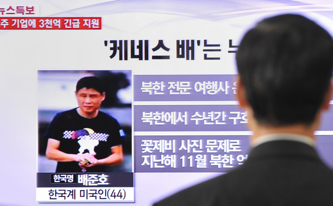 Un trecător urmăreşte o emisiune de televiziune locală din Seul la 2 mai 2013 care arată un raport şi o imagine a lui Kenneth Bae