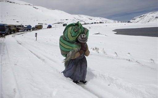 O femeie merge pe un drum acoperit de zapada, pe muntele La Cumbre, in a Paz, Bolivia, 25 August 2013. (AP Photo/Juan Karita)
