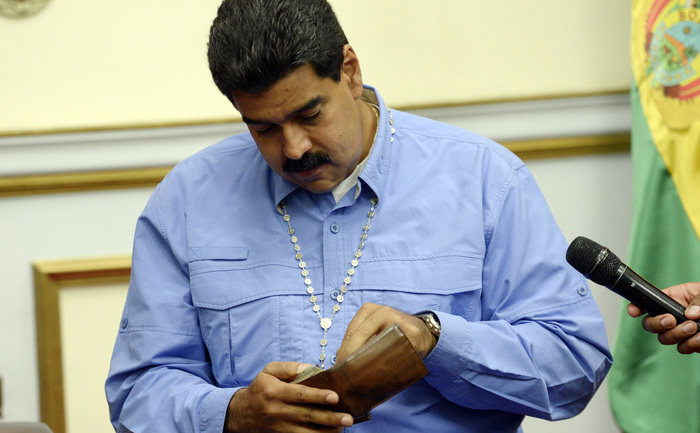 
Venezuela: Preşedintele Nicolas Maduro verifică portofelul în timpul unei vizite a Preşedintelui bolivian Evo Morales (nu în foto) la palatul prezidenţial Miraflores de la Caracas la 27 septembrie 2013.