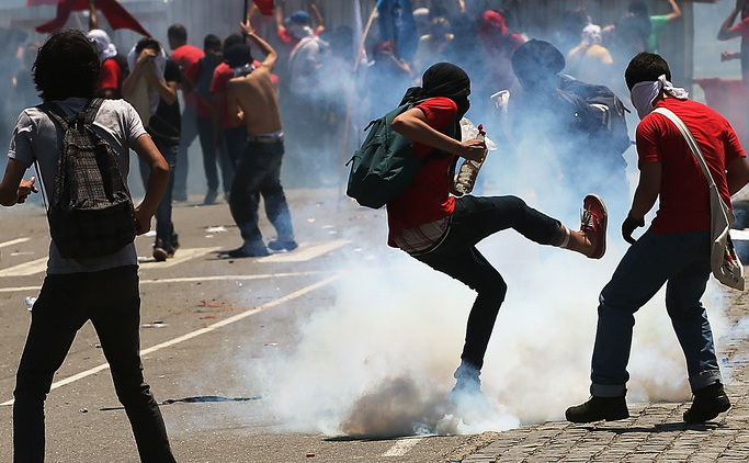Rio - protestatar dă cu piciorul unei grenade fumigene aruncate de poliţie. 21 octombrie 2013