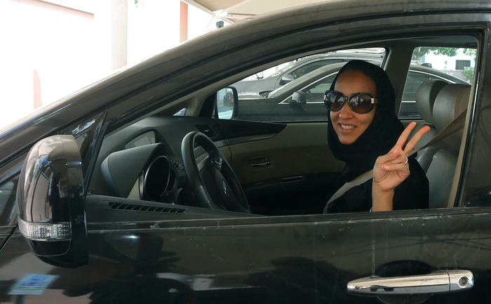 Activista saudita Manal Al Sharif, care traieste actualmente in Dubai, aratand semnul victoriei in timp ce se afla la volanul masinii sale, 22 octombrie 2013. (MARWAN NAAMANI / AFP / Getty Images)