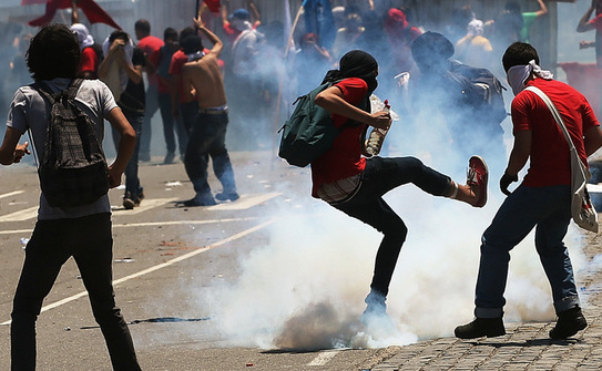 Rio - protestatar dă cu piciorul unei grenade fumigene aruncate de poliţie. 21 octombrie 2013 (Mario Tama / Getty Images)