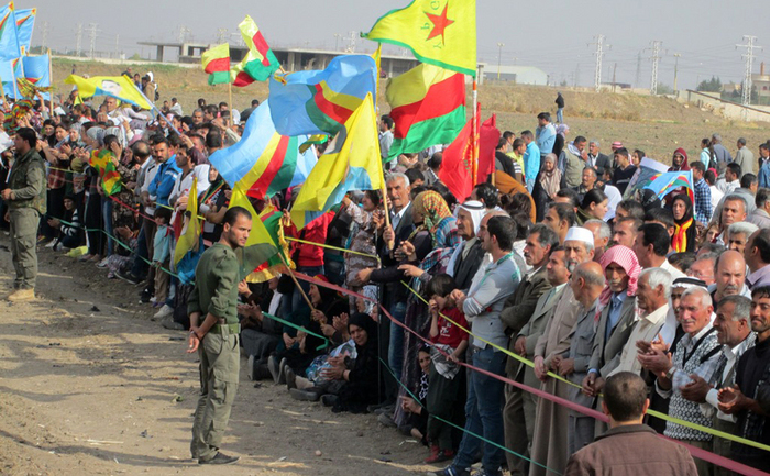 
Kurzii sirieni fluturând steaguri la graniţa cu Turcia, în apropiere de districtul Nusaybin Mardin, la 7 noiembrie 2013. Kurzii protestează împotriva construcţiei de către guvernul turc a unui zid de 2,5 km lungime de-a lungul graniţei dintre Turcia şi Siria.