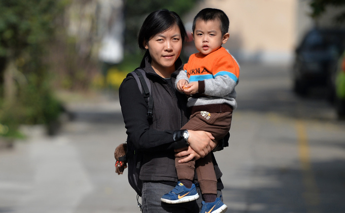 
O mamă îşi ţine copilul în braţe în Shanghai, 16 noiembrie 2013, la câteva zile după ce la o întâlnire cheie a conducerii comuniste din Beijing s-a anunţat că regimul chinez va permite cuplurilor să aibă doi copii dacă unul dintre părinţi a fost un copil unic în familia sa.