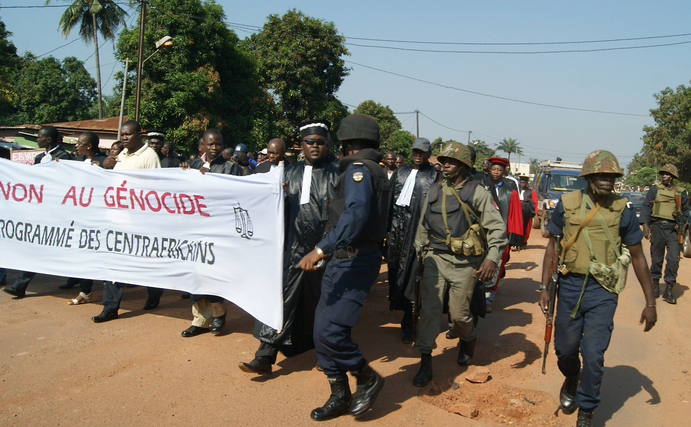 Oamenii ţin un baner pe care scrie „Nu genocidului organizat pentru centru-africani” 22 octombrie 2013.