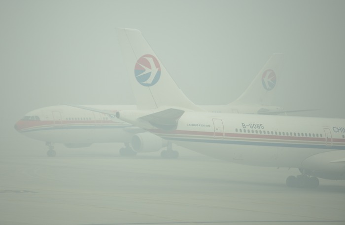Aeronavele sunt abia vizibile prin smogul gros pe pista aeroportului Hongqiao din Shanghai, 06 decembrie 2013.