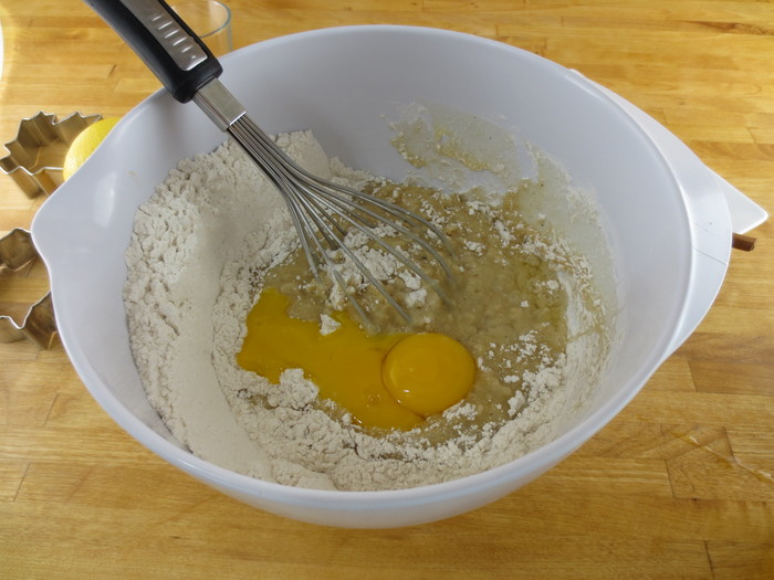 Siropul se toarnă peste amestecul de făină, amestecând uşor. Se adăugă gălbenuşurile de ou şi smântâna
