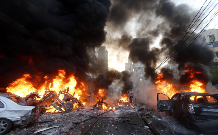 Flacarile ies din autoturisme incendiate in urma exploziei unei masini capcana ce a vizat suburbia din sudul Beirutului, la 02 ianuarie 2014. (- / AFP / Getty Images)