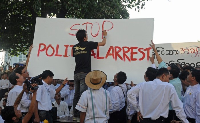 Un protestatar scrie pe o pancardă textul „Stop arestului politic”. Zeci  de jurnalişti din Birmania au organizat o adunare publică în Yangon  pentru a protesta împotriva pedepsei cu  închisoarea, aplicată uneia dintre colegele lor, 5 ian 2014. 
