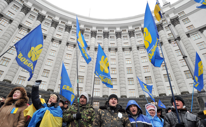 Protestari fluturând steagul partidului Svoboda în Kiev.