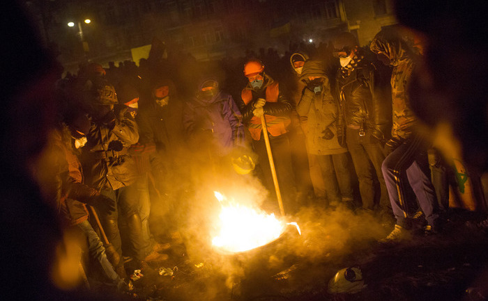 Protestatarii stau adunaţi în jurul unui foc în timpul confruntărilor de pe 23 ianuarie 2014, Kiev. (Rob Stothard / Getty Images)