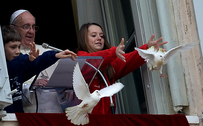 Doi copii, aflaţi lângă Papa Francis, eliberează porumbei albi în semn de pace