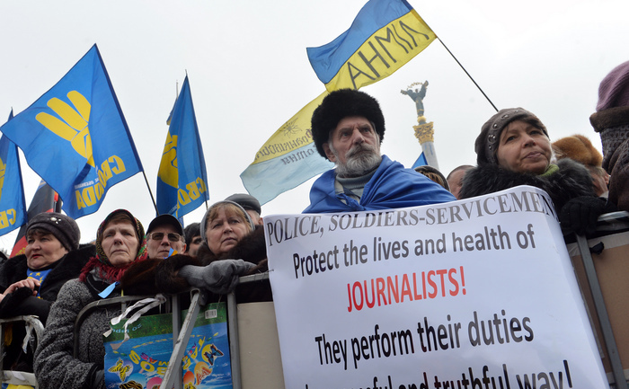 Protest în Piaţa Independenţei din Kiev, 9 februarie 2014. Un protestatar ţine o pancartă cu un mesaj de sprijin pentru junalişti.