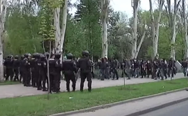 Grupul înarmat pro-Rusia trece pe lângă jandarmii din Doneţk.