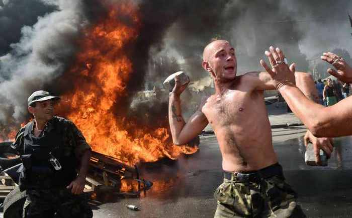 Activişti de pe Euro Maidan-ul din Kiev, rezistând pe 7 august împotriva încercării autorităţilor oraşului de a elibera zona. Mulţi ucraineni din Kiev sunt de părere că actualele demonstraţii sunt opera agenţilor ruşi, inflitraţi (SERGEI SUPINSKY/AFP/Getty Images)