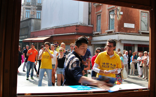 Practicantii Falun Gong sunt agresati in timpul unei manifestatii pacifice desfasurate In Piata Campo S.Bartolomeo, in Venetia, Italia. (Marius Iacob / Epoch Times Italia)