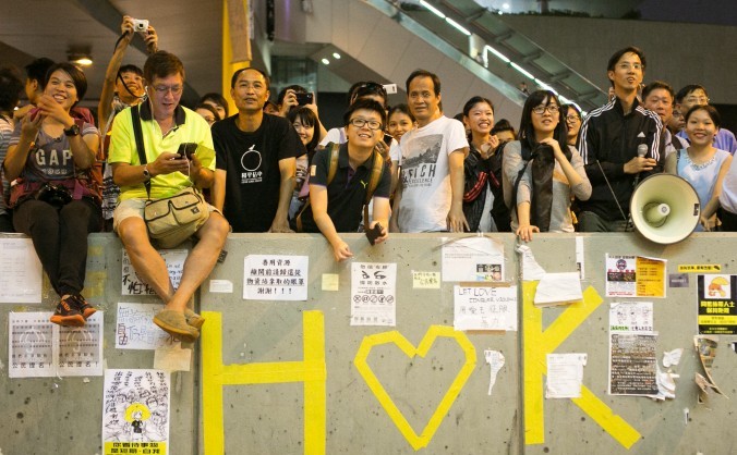 
 
Manifestanţi pro-democraţie zambesc în districtul central al Hong Kong-ului, 7 octombrie 2014.
 