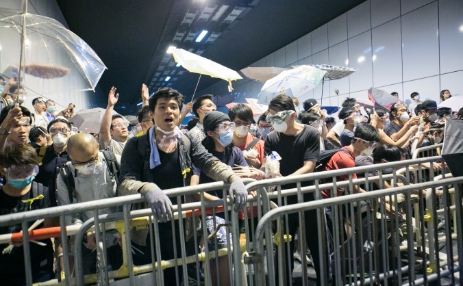 

Manifestanţii pro-democraţie se încleştează cu poliţia după ce au încercat să blocheze bulevardul Lung Wo din Hong Kong, ca răspuns la decizia poliţiei de a înlătura bariere şi de a deschide un drum ocupat, 14 octombrie 2014.
