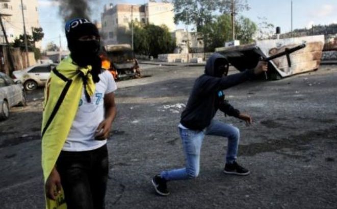 
Un manifestant palestinian trage cu o armă improvizată asupra forţelor de securitate israeliene în timpul ciocnirilor violente din Ierusalimul de Est, 30 octombrie 2014.