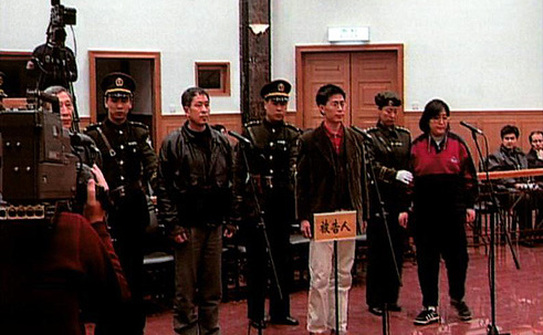 Wang Zhiwen (al treilea din stânga) este adus în faţa instanţei alături de alţi practicanţi Falun Dafa în noapte de 26 decembrie, 1999. Acest proces era menit să-i influenţeze pe ceilalţi practicanţi, contribuind la eforturie care trebuiau să-I determine să renunţe la disciplina spirituală (Prin bunăvoinţa familiei lui Wang.)