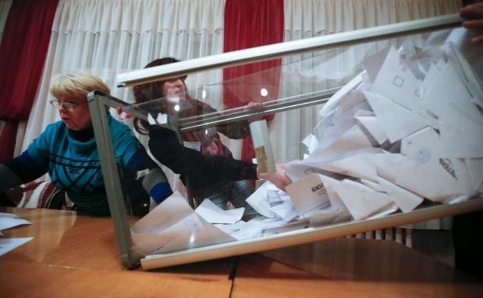 
Membrii unei comisii electorale locale golesc o urnă de vot la o secţie de votare din Doneţk, 2 noiembrie 2014.