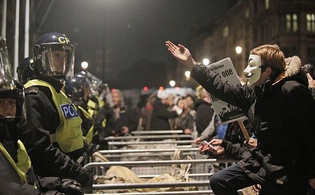 
Manifestanţii Anonymous discută aprins cu forţele de ordine din Londra, 5 noiembrie 2014.
