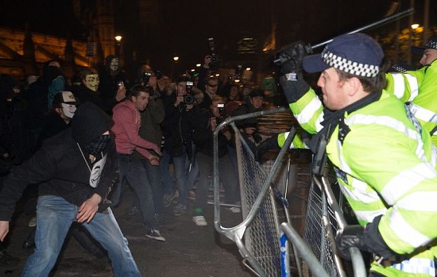 Ofiţerii de poliţie îşi folosesc bastoanele împotriva manifestanţilor Anonymous, 5 noiembrie 2014.