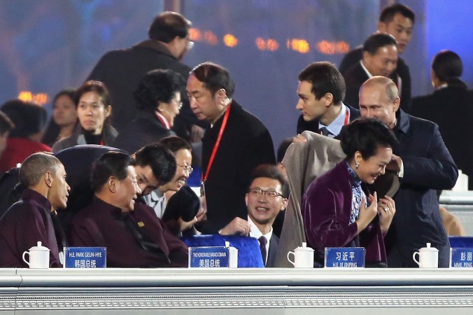 Vladimir Putin pune pe un şal pe umerii soţiei preşedintelui chinez Xi Jinping, Peng Liyuan, în timp ce Xi Jinping şi Barack Obama se uită la un spectacol de artificii