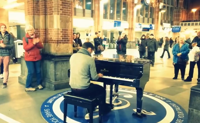 Valentin Astănculesei cântă la pian în gara din Amsterdam.