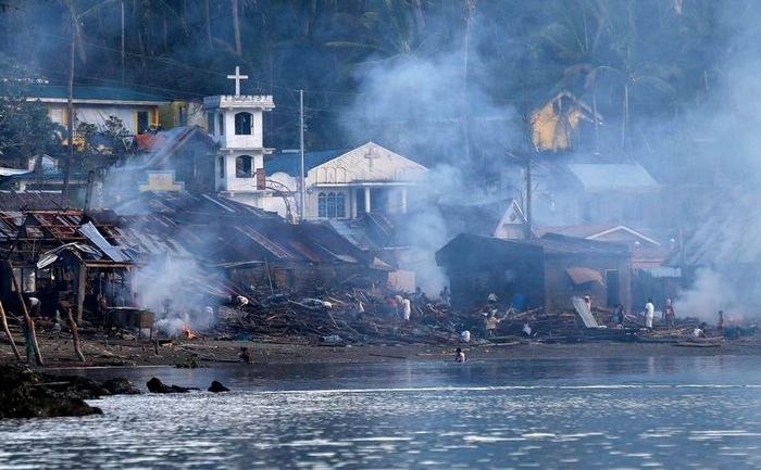 Victimele taifunului Hagupit ard gunoaie într-un sat de coastă pe insula filipineză Samar, 8 decembrie 2014. (Captură Foto)