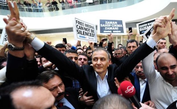 Redactorul şef al ziarului Zaman, Ekrem Dumanli, face cu mâna susţinătorilor în timp ce arestat de forţele de ordine, 14 decembrie 2014.