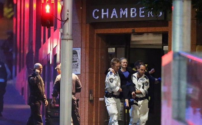 

Poliţiştii scot o femeie din cafeneaua Lindt din centrul oraşului australian Sydney, după ce un bărbat înarmat a ţinut ostatici 17 oameni timp de 16 ore.
