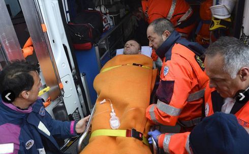 Membrii unei echipe de salvare ajută un pasager salvat de pe feribotul Norman Atlantic, în portul Bari din Marea Adriatică. (Captură Foto)