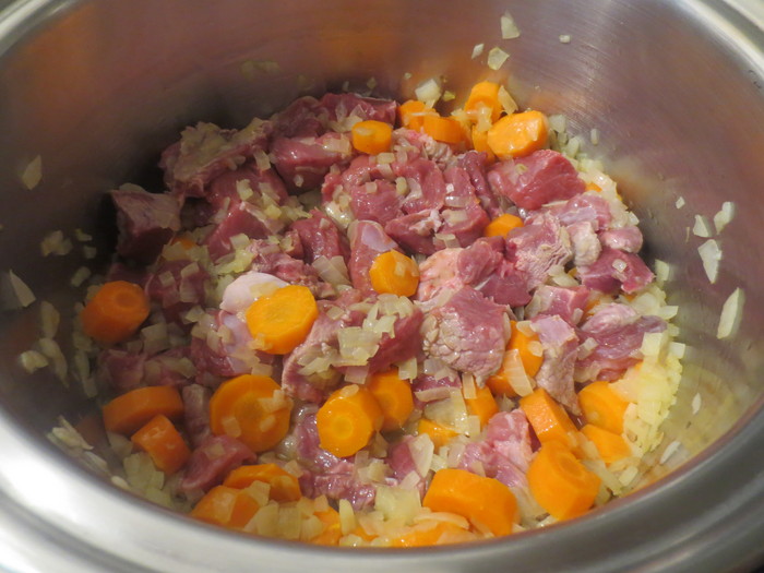 Peste ceapă şi morcovi de adaugă bucăţile de carne tăiate în cubuleţe
 