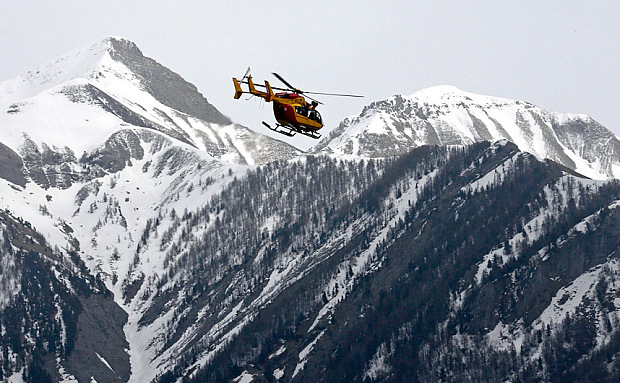 Un elicopter al serviciului francez pentru securitate civilă zboară  deasupra Alpilor în timpul operaţiunilor de căutare a rămăşiţelor  avionului Airbus A320, 24 martie 2015.