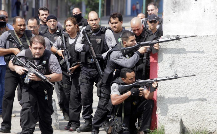 Ofiţeri de poliţie în timpul unui schimb de focuri cu traficanţii de droguri din favela Vila Cruzeiro din Rio de Janeiro, 2010.
