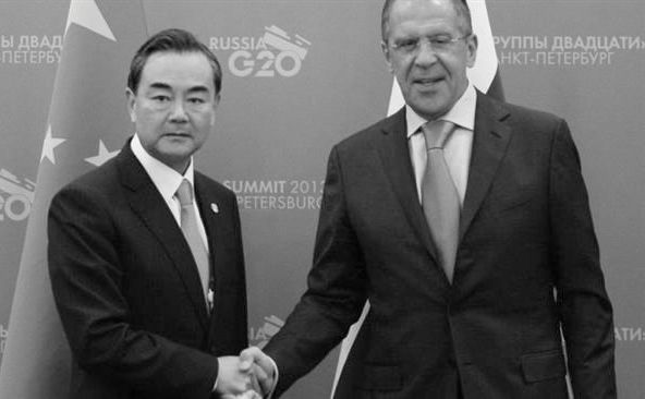 Ministrul chinez de externe Wang Yi (st) dă mâna cu omologul său rus Serghei Lavrov.