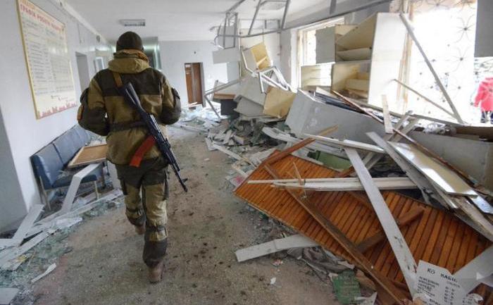 Un  rebel separatist stă de pază într-un spital bombardat în districtul  Tekstylnyk din Doneţk, 4 februarie 2015. În ziua Paştelui Ortodox, un  alt spital a fost bombardat în districtul Kuibîşevski din vestul  oraşului Doneţk.