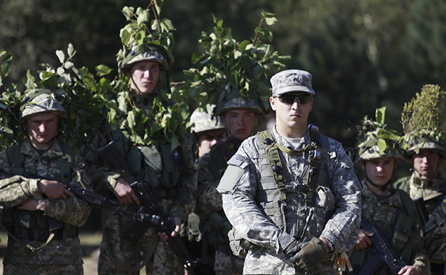 Un soldat american (centru) este însoţit de soldaţi ucraineni, în timpul unui exerciţiu militar desfăşurat lângă orasul Iavoriv.