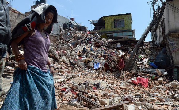 O femeie trece pe lângă o casă prăbuşită în Kathmandu.