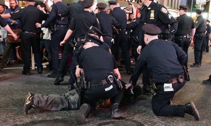 Un manifestant este arestat de poliţia din new York în timpul unui marş către Times Square.