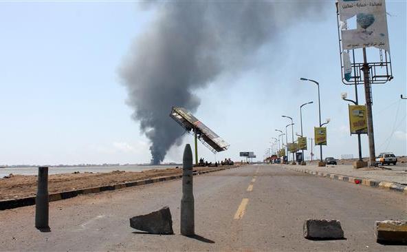 Fumul  se ridică la orizont în timp ce militanţii Al-Qaeda încearcă sa  blocheze un drum în al-Mansura, est de oraşul yemenit Aden, 29 aprilie  2015.