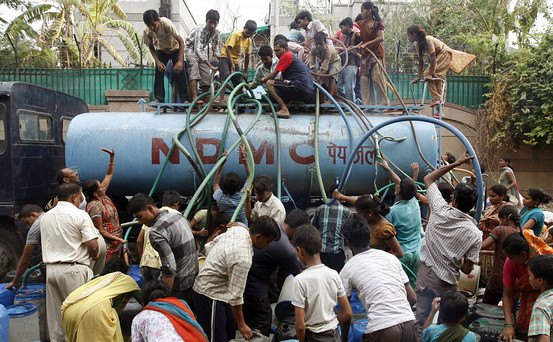 Cetăţeni indieni se aprovizionază cu apă dintr-o cisternă în New   Delhi.
