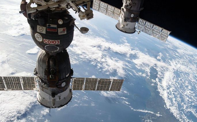 Un cargou spaţial rusesc Progress (dr) în timpul unei misiuni de livrare de provizii către Staţia Spaţială Internaţională.