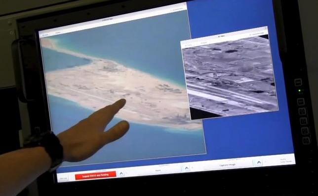 Un membru al echipajului avionului american P-8A  Poseidon prezintă imagini cu activităţile de contrucţie chineze pe  Reciful Fiery Cross în disputatele Insule Spratly, Marea Chinei de  Sud. (Captură Foto)