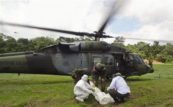 Ofiţerii poliţiei columbiene transportă trupul unui rebel ucis într-o operaţiune militară în municipalitatea Carepa, Columbia.