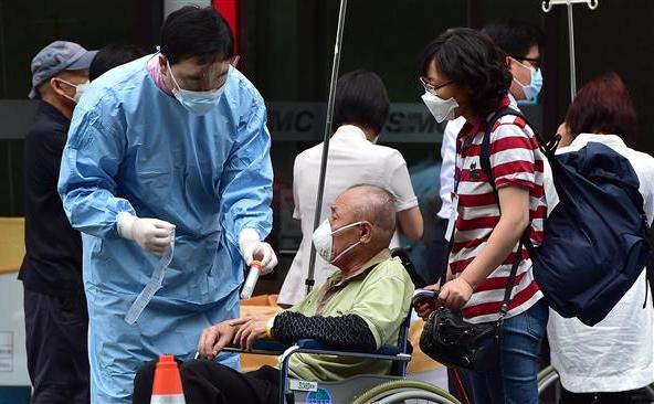 Un angajat medical recolectează mostre de la un bărbat suspectat ca fiind infectat cu MERS la Centrul Medical Samsung din Seul, 8 iunie 2015.