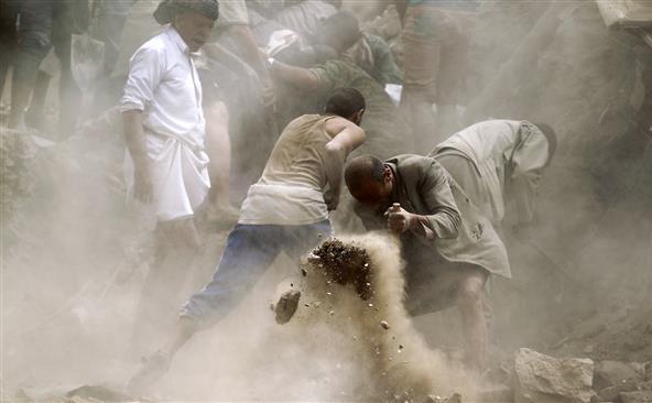 Yemeniţii caută supravieţuitori printre dărâmăturile unor case distruse de o lovitură aeriană saudită în capitala Sana’a, 12 iunie 2015.
